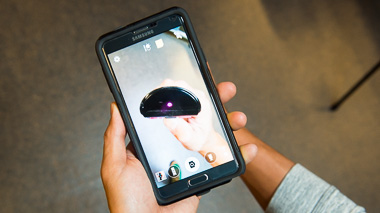 Photo of a person using their smartphone camera to see infrared radiation from a remote control